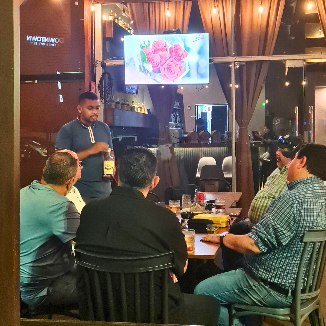 Ambiente del Encuentro de Bon Vivants en Taberna Tres Barriles, con invitados disfrutando tabacos A Mano De Verdad y Ron El Galante en Costa del Este, Panamá.